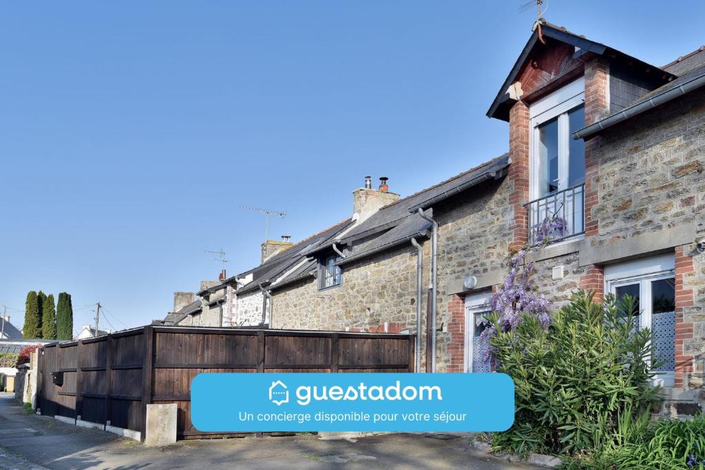 une rangée de maisons en briques avec un panneau indiquant Gibsonovation dans l'établissement La Saudrais - Parking - Jardin, à Dinard