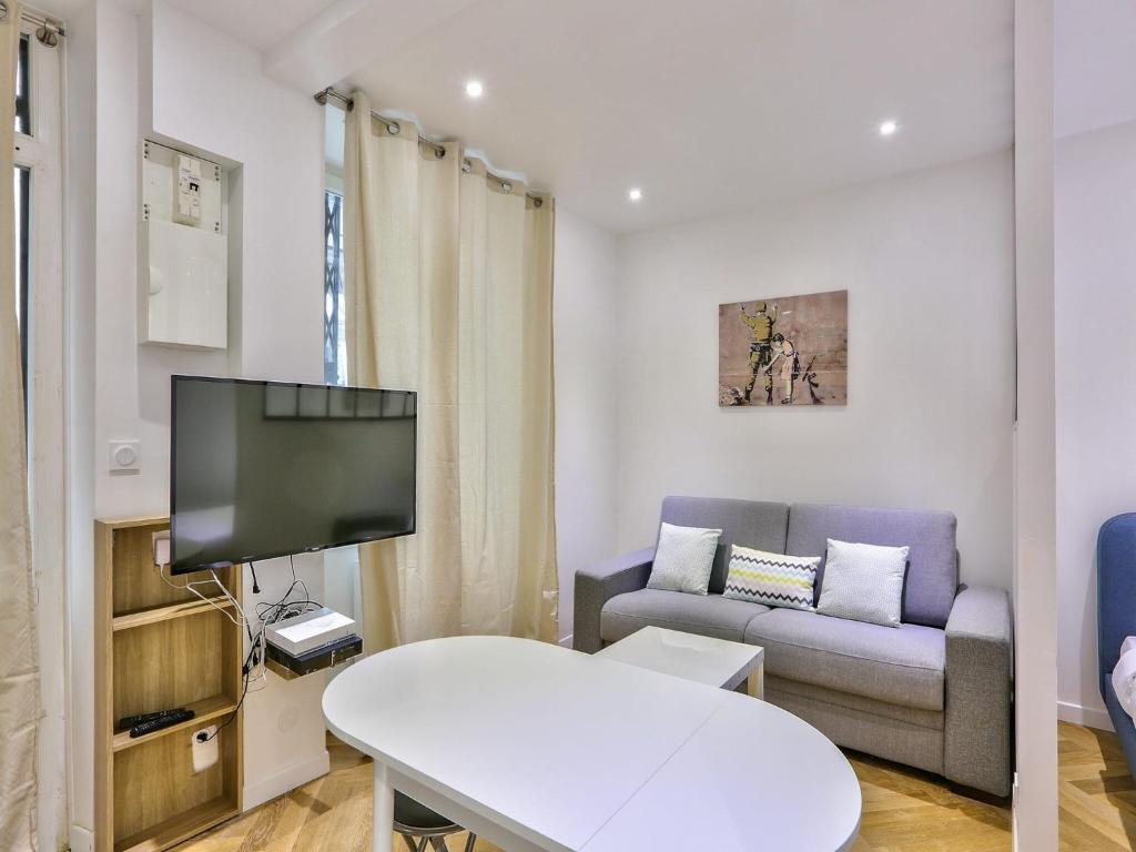 un salon avec un canapé et une table dans l'établissement Cosy apartment - 1BR 4P - Sentier Grand Rex, à Paris