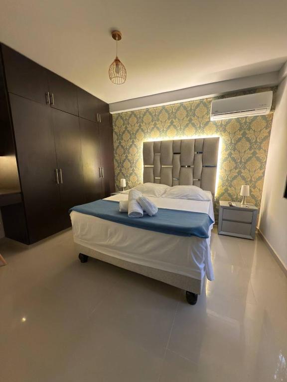 a bedroom with a large white bed with blue sheets at Granada Luxury Loft in Cali
