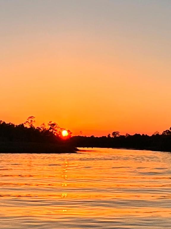 an orange sunset over a body of water at Gulf Coast Waterfront Home in Shoreline Park
