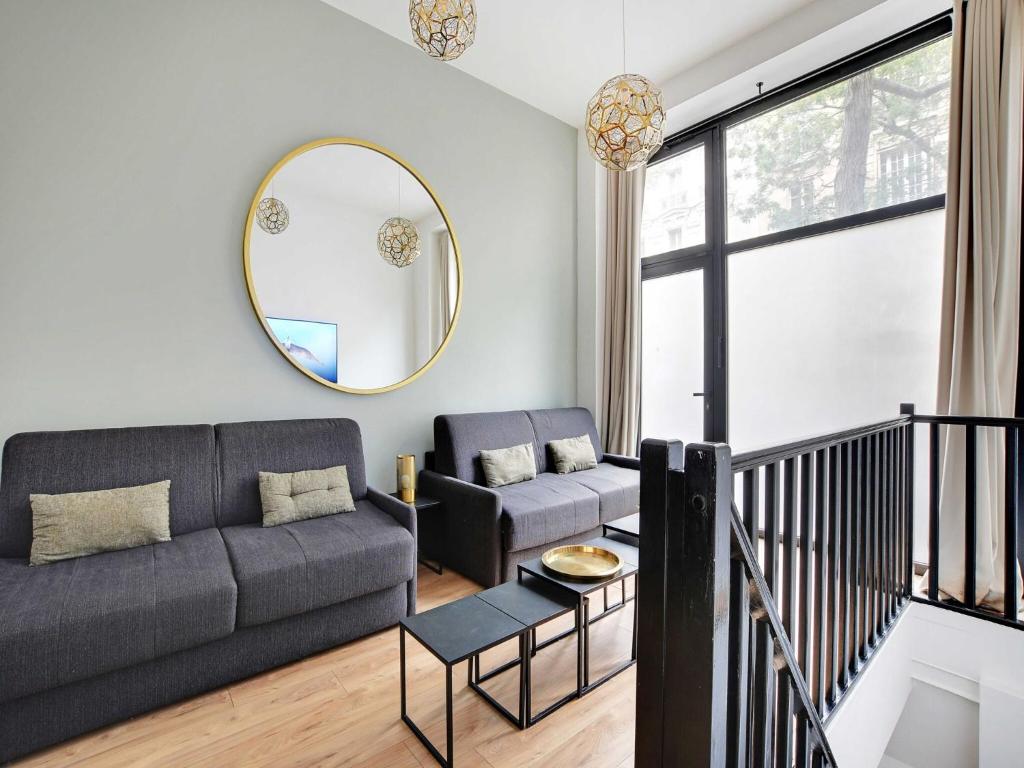 un salon avec un canapé et un miroir dans l'établissement Welcoming apartment -2BR 8P- Bel-Air, à Paris