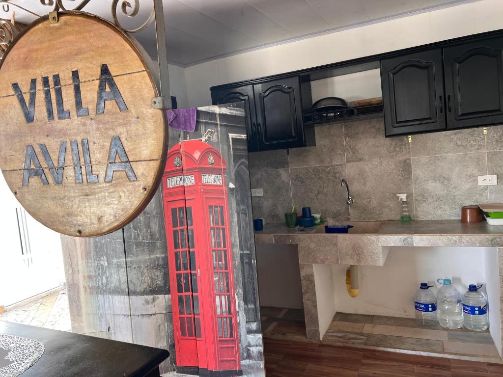 a red phone booth in a kitchen next to a kitchen at Villa Isla fuerte Ávila in Moñitos