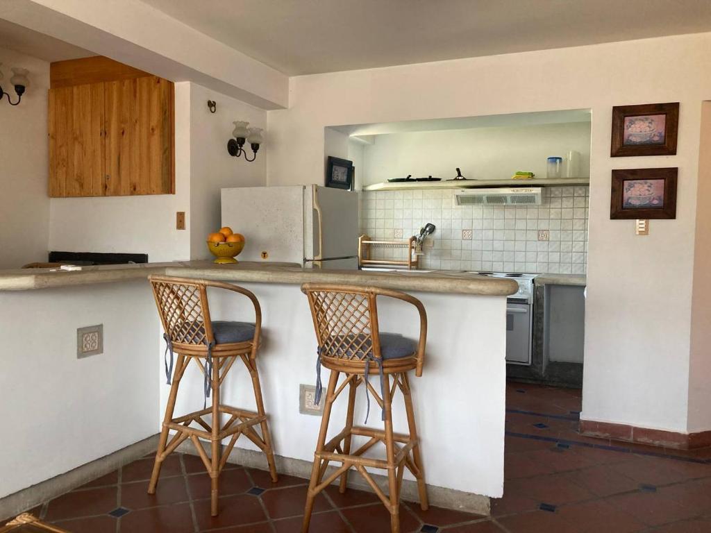eine Küche mit zwei Barhockern an der Theke in der Unterkunft Valle Sol in El Valle del Espíritu Santo