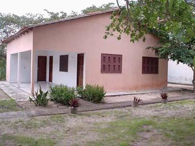 a small white house with a tree in front of it at Residencial Recanto do Paraiso in Jericoacoara