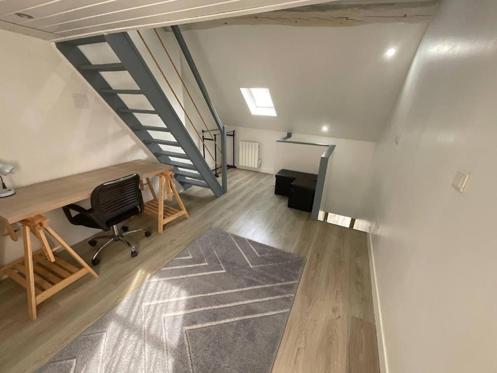 un bureau mansardé avec un bureau et une chaise dans l'établissement 8 les maradas bruns, à Pontoise