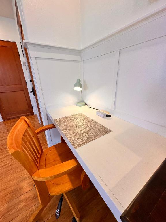 a room with a white table and a chair at Hilo Town Inn in Hilo