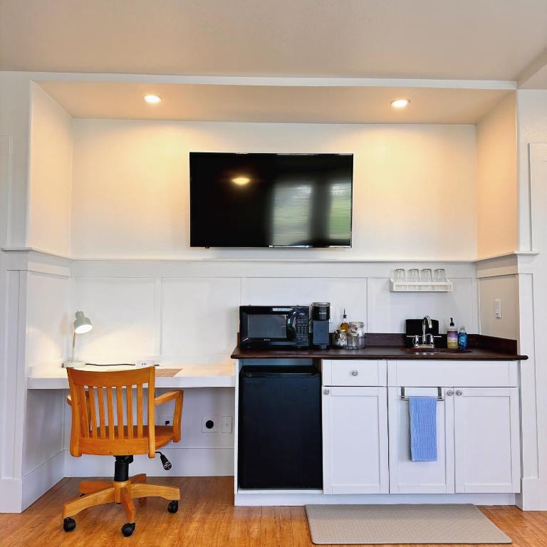 a kitchen with a desk and a television on the wall at Hilo Town Inn in Hilo