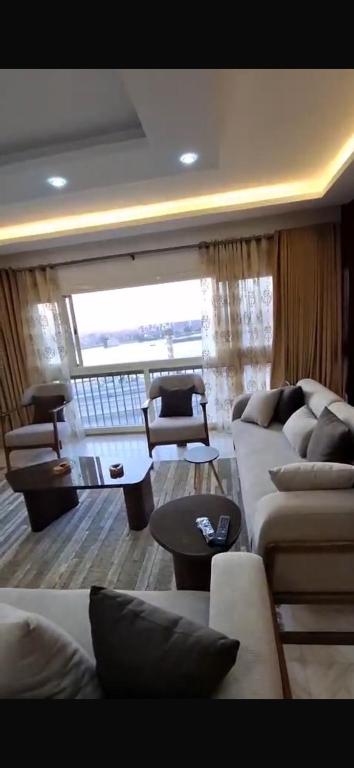 a living room with two couches and a table at Deluxe Direct Nile Apartment in Cairo