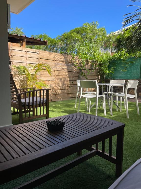 a patio with a table and chairs and a fence at Prana Lodge Saint Gilles les Bains 800 m de la plage in Saint-Gilles-les-Bains
