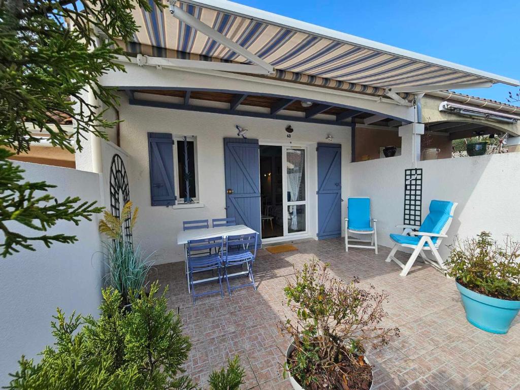 d'une terrasse avec des chaises, une table et un auvent. dans l'établissement Maison vacances Meschers 6 pers, proches plages - FR-1-550-88, à Meschers-sur-Gironde