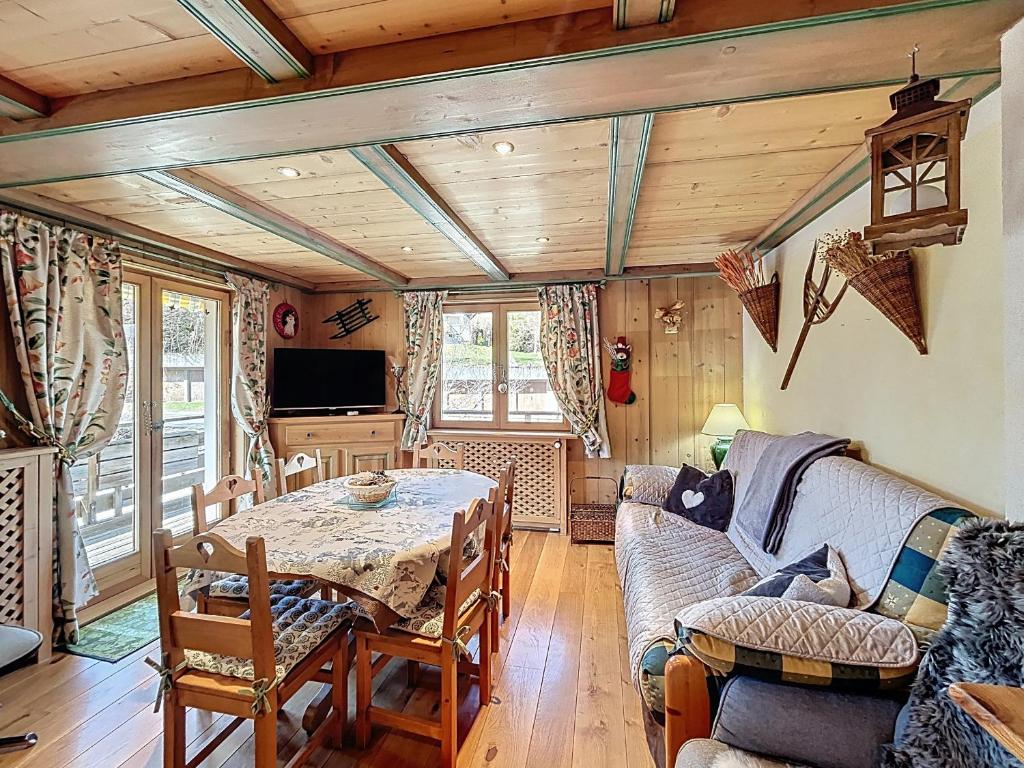 un salon avec une table et un canapé dans l'établissement Appartement cosy proche centre village avec balcon et parking - FR-1-560-161, à Combloux
