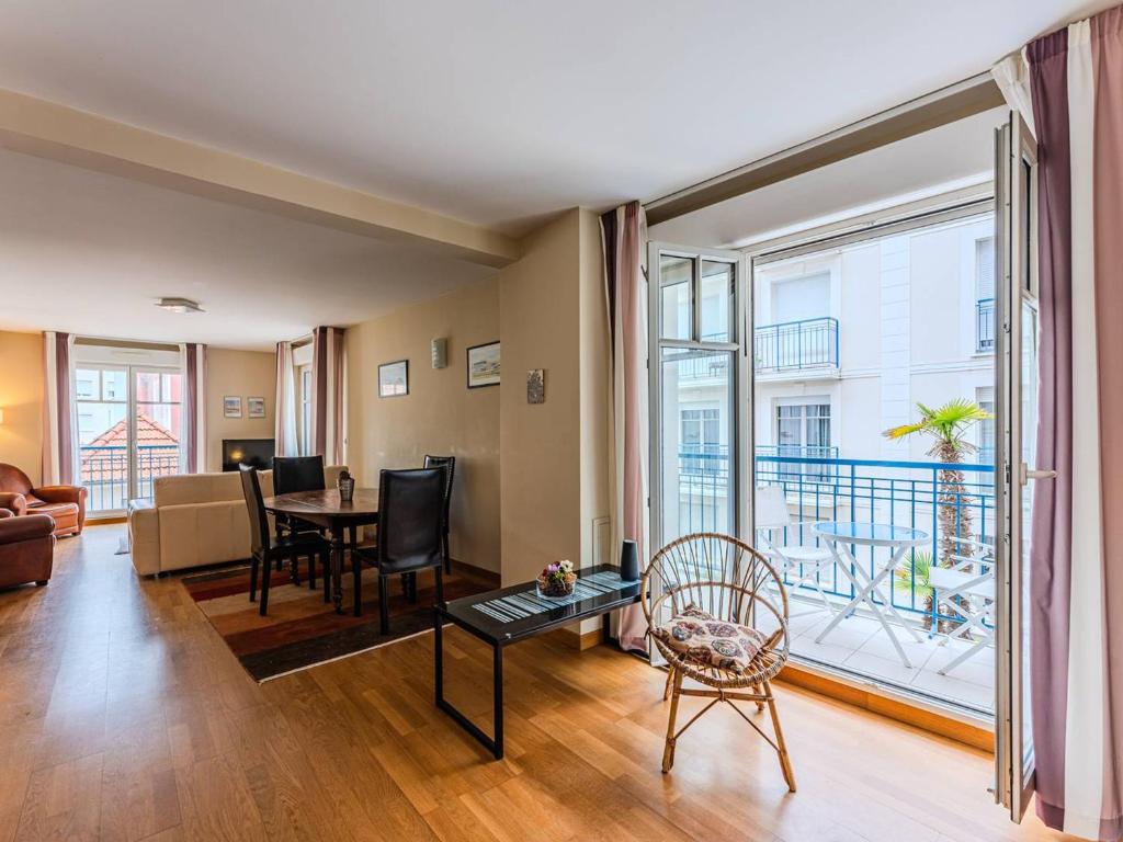 - un salon avec une table, des chaises et une grande fenêtre dans l'établissement Arcachon : Superbe T2 à 100m de la plage avec parking, Wifi - FR-1-433-138, à Arcachon