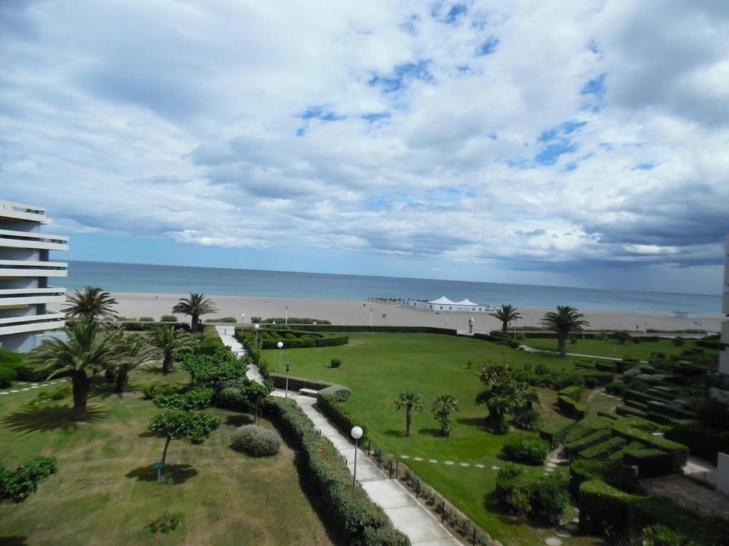 - une vue sur un parc avec la plage en arrière-plan dans l'établissement Studio cabine face mer avec parking privé, Canet-Plage - FR-1-750-69, à Canet