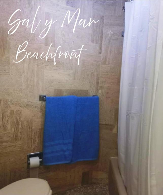 a bathroom with a blue towel next to a toilet at Torres Gemelas Acapulco Suites in Acapulco