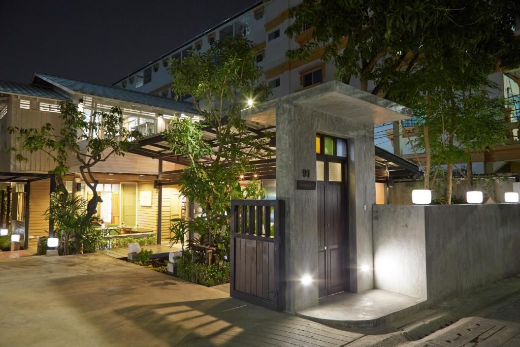 a house with a wooden door in front of a building at Uncle Loy's Boutique House in Bangkok