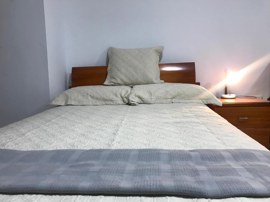 - un lit avec une couette et des oreillers bleus et blancs dans l'établissement "La casa de mi tia" Agradable, Acogedor, Tranquilo, à Envigado