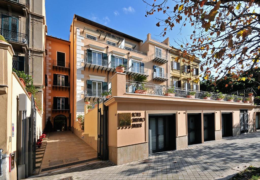 Un grand bâtiment avec balcon se trouve dans une rue. dans l'établissement Hotel Giardino Inglese, à Palerme