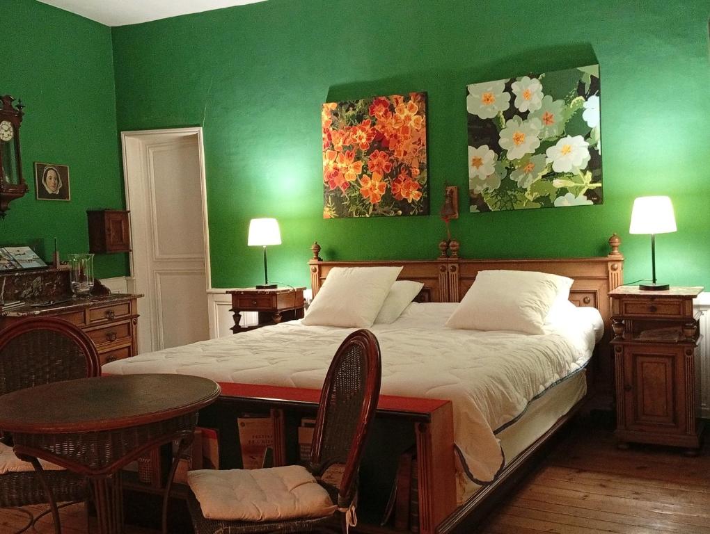 ein grünes Schlafzimmer mit einem Bett, einem Tisch und Stühlen in der Unterkunft La Villa RYPS in Saint-Valery-sur-Somme