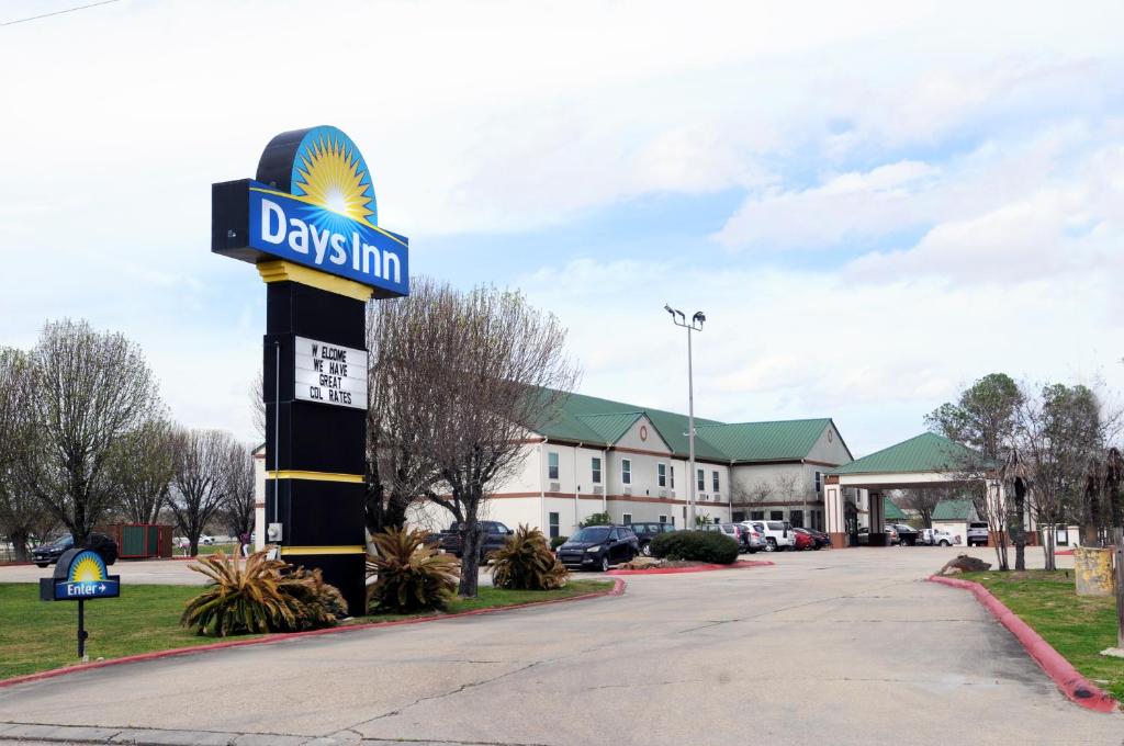 Un cartel de una posada para perros frente a un edificio. en Days Inn by Wyndham Denham Springs-Baton Rouge East, en Denham Springs
