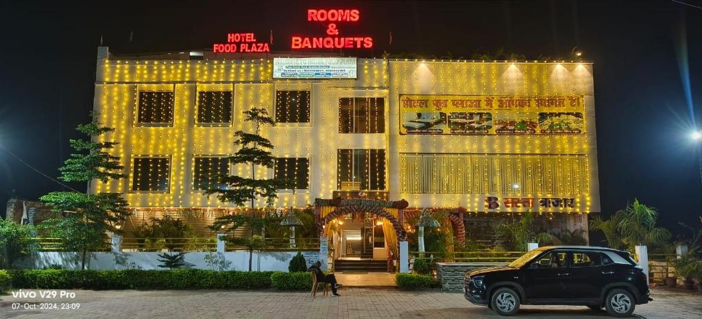 NaugachiaにあるFood Plaza Hotel Shreyash Innの灯台付き建物前に停車する車