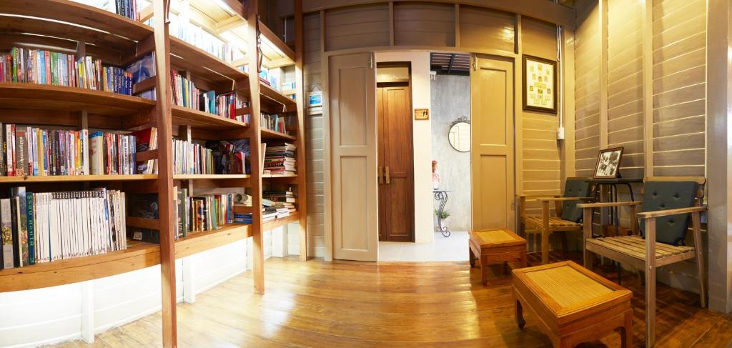 a library with wooden shelves filled with books at Uncle Loy's Boutique House in Bangkok