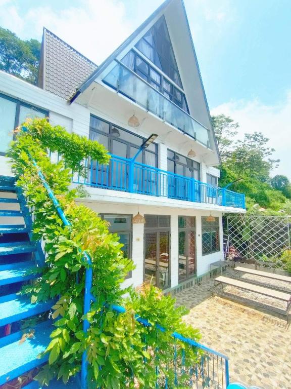 a house with blue stairs and a blue railing at Sa Mộc House - Tam Đảo căn Mộc 6 phòng ngủ in Tam Ðảo