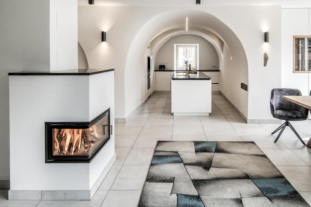 コッレ・イザルコにあるVilla Tribulaunblick - Exklusives Designapartment mit Kamin, Traumterrasse und Panoramablickの暖炉とテーブルのあるリビングルーム