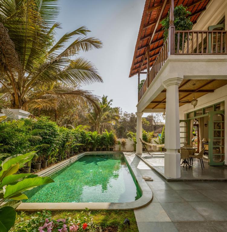 a swimming pool in the yard of a house at Villa Fado - 4BHK Luxury Villa with Big Private Pool, Kitchen, Balcony, Patio, Caretaker, Power Backup, Security & WiFi located closer to Vagator Beach in Assagao