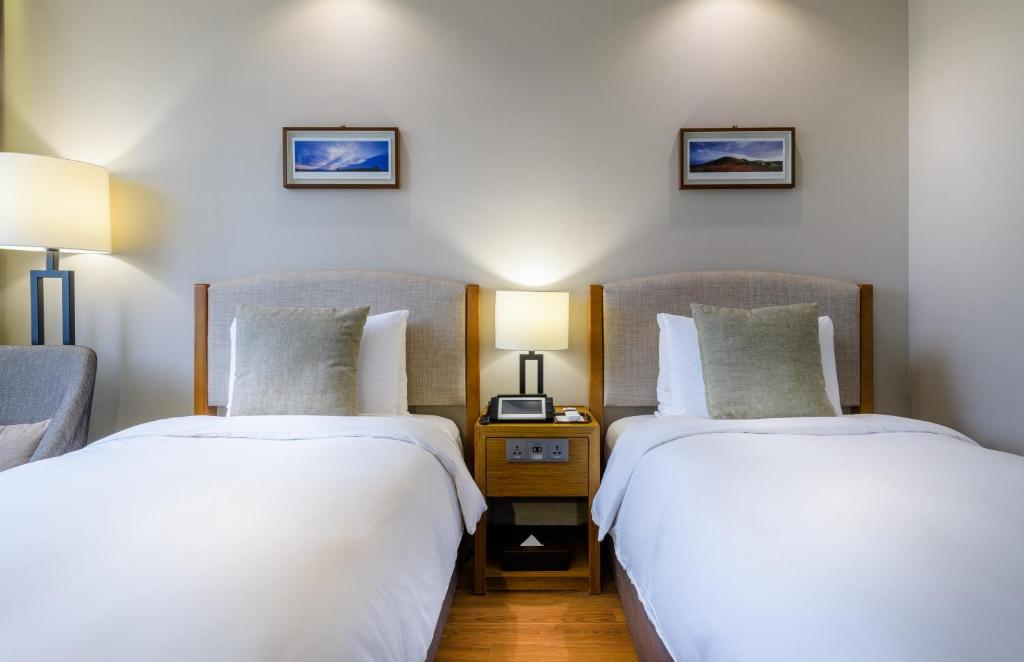 two beds sitting next to each other in a room at Parksunshine Jeju in Seogwipo