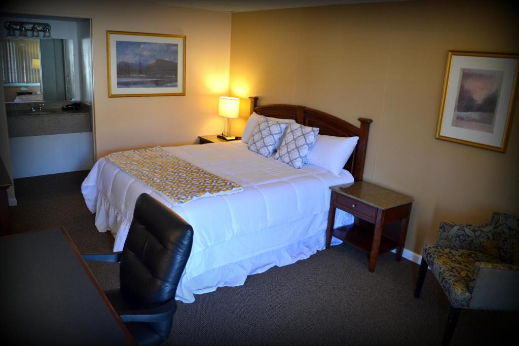 um quarto de hotel com uma cama e uma cadeira em Wayne Inn em Honesdale