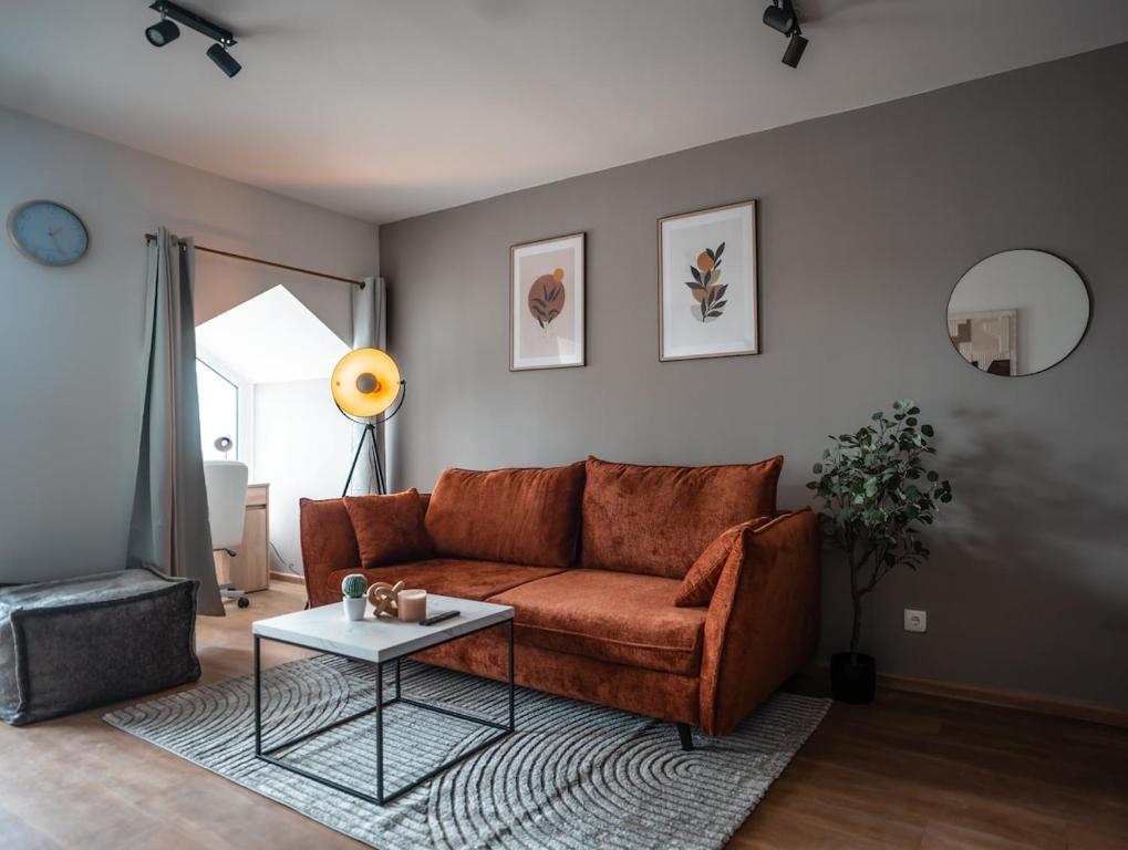 a living room with a brown couch and a table at Wohnbude Hauptbahnhof in Vienna