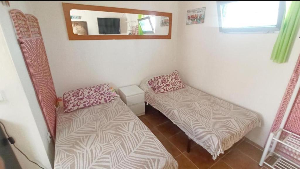 a small room with two beds and a mirror at Beachfront Studio with Private Kitchen and Bath in Algeciras