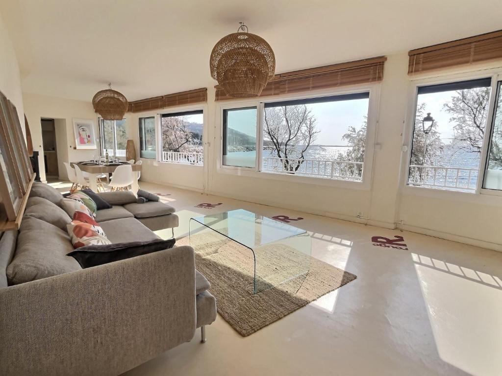 un salon avec un canapé et une table en verre dans l'établissement Coco Beach, à Carqueiranne