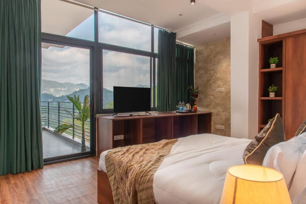 a bedroom with a bed and a large window at Royal Apartments Kasauli I Restaurant I Lift I Roof top Cafe I Self cooking also available I Bonfire I Best View in Kasauli