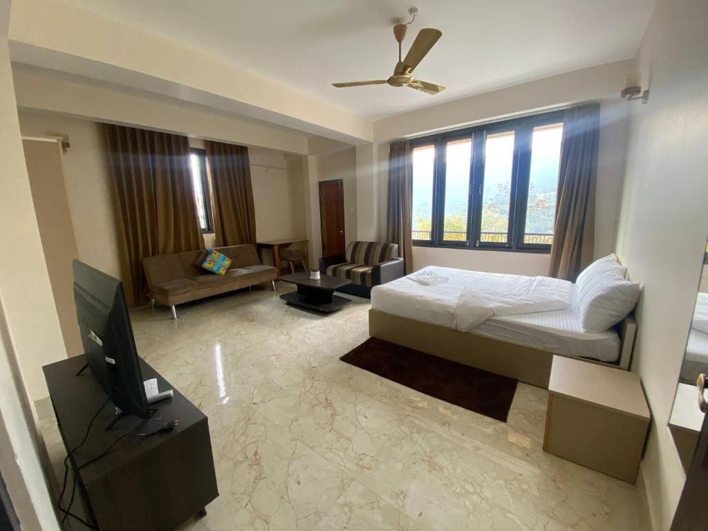 a hotel room with a bed and a television at Home away from home in Gangtok