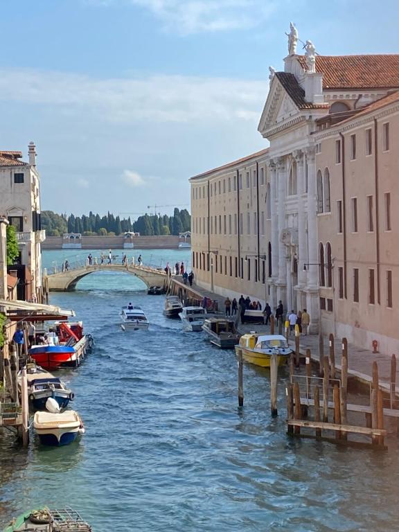 a group of boats in a river next to buildings at Residenza Stardust Suite with Canal View in Venice