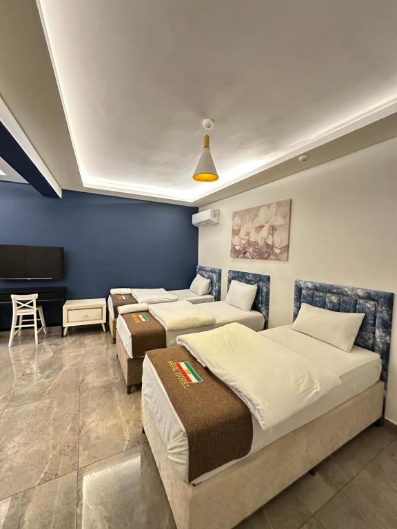 a room with three beds and a flat screen tv at Sevil new apart in Istanbul