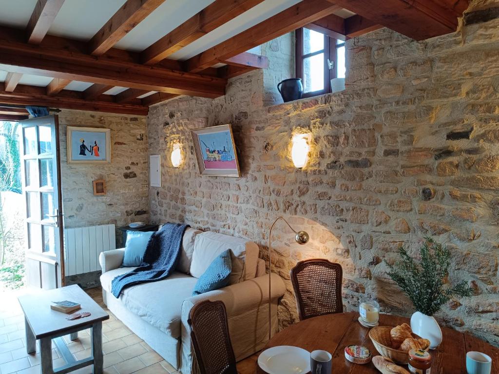 un salon avec un canapé et une table dans l'établissement Le Bray, à Colleville-sur-Mer
