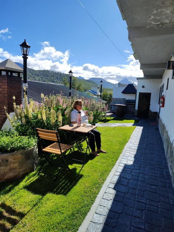 a woman sitting at a picnic table in a garden at 615 in Ushuaia