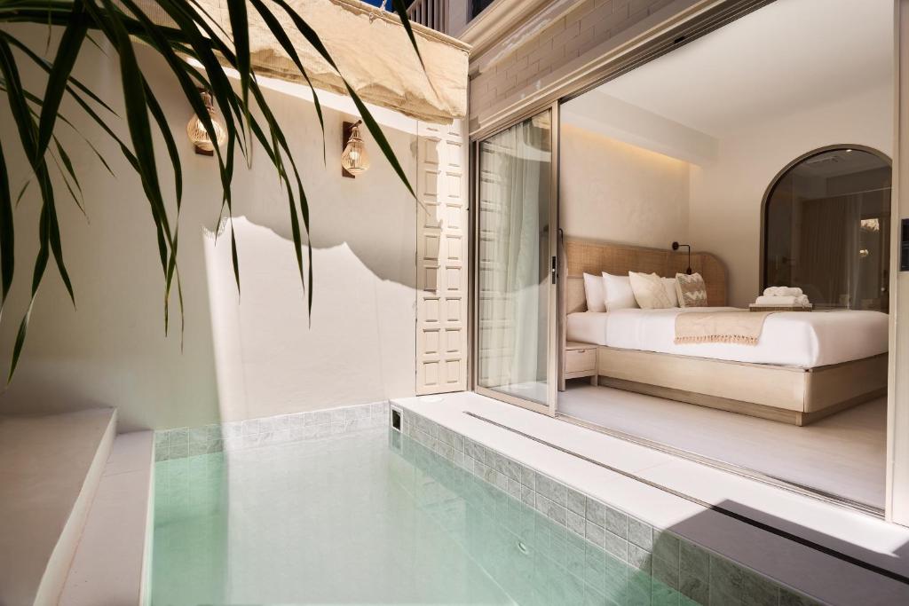 a bedroom with a bed and a pool in a room at PE-LA Thapae Boutique Hotel in Chiang Mai
