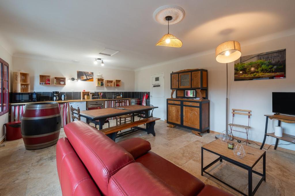 - un salon avec un canapé rouge et un bar dans l'établissement Domaine Fouet - A 100m du Domaine visite de cave et dégustation gratuite, à Saint-Cyr-en-Bourg