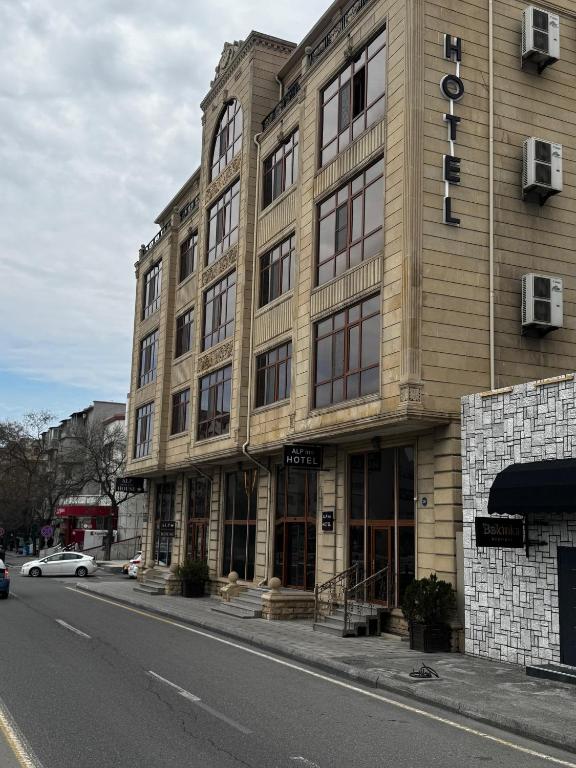 巴库阿尔普酒店 的街道上的建筑物,前面有停车位