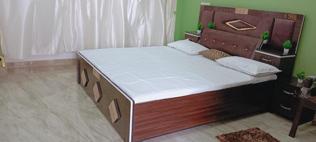 FaizābādShri Balaji Home Stay的一张大床,在房间内配有木制床头板