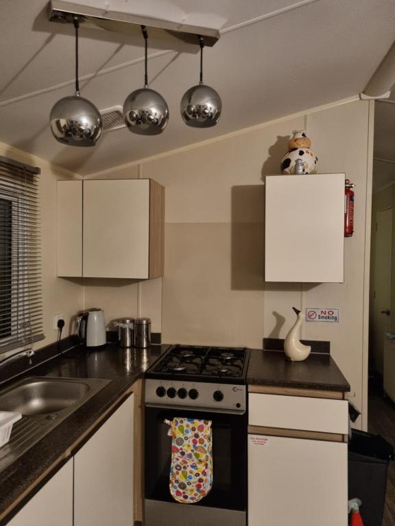 a kitchen with a stove top oven next to a sink at fantasy island in Ingoldmells