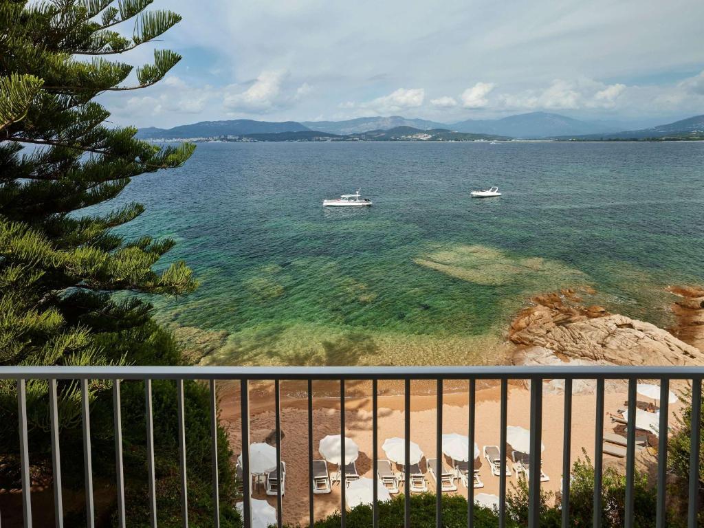 two boats in the water on a beach at Sofitel Golfe d'Ajaccio Thalassa Sea & Spa in Ajaccio