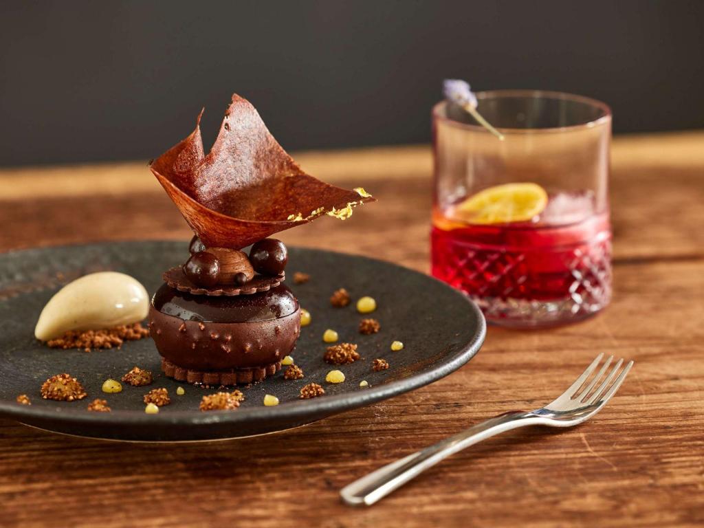 a plate with a dessert on a table with a drink at Sofitel Golfe d'Ajaccio Thalassa Sea & Spa in Ajaccio