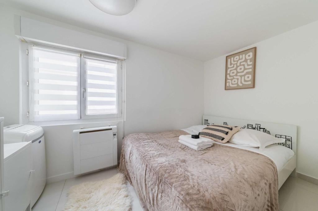 une chambre blanche avec un lit et une fenêtre dans l'établissement Appartement Cosy metro saint paul - 4P - Paris 4, à Paris