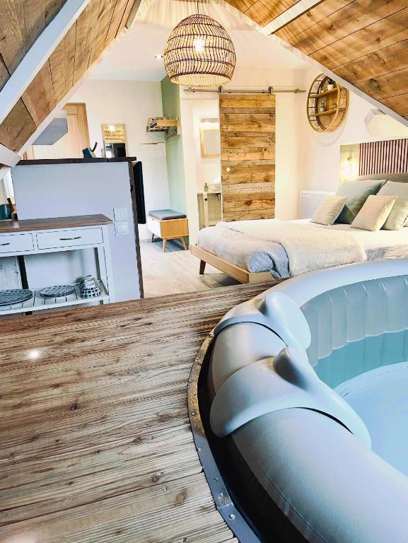 ein Schlafzimmer mit großem Bett und Kamin in der Unterkunft Escale en Avesnois in Croix-Caluyau