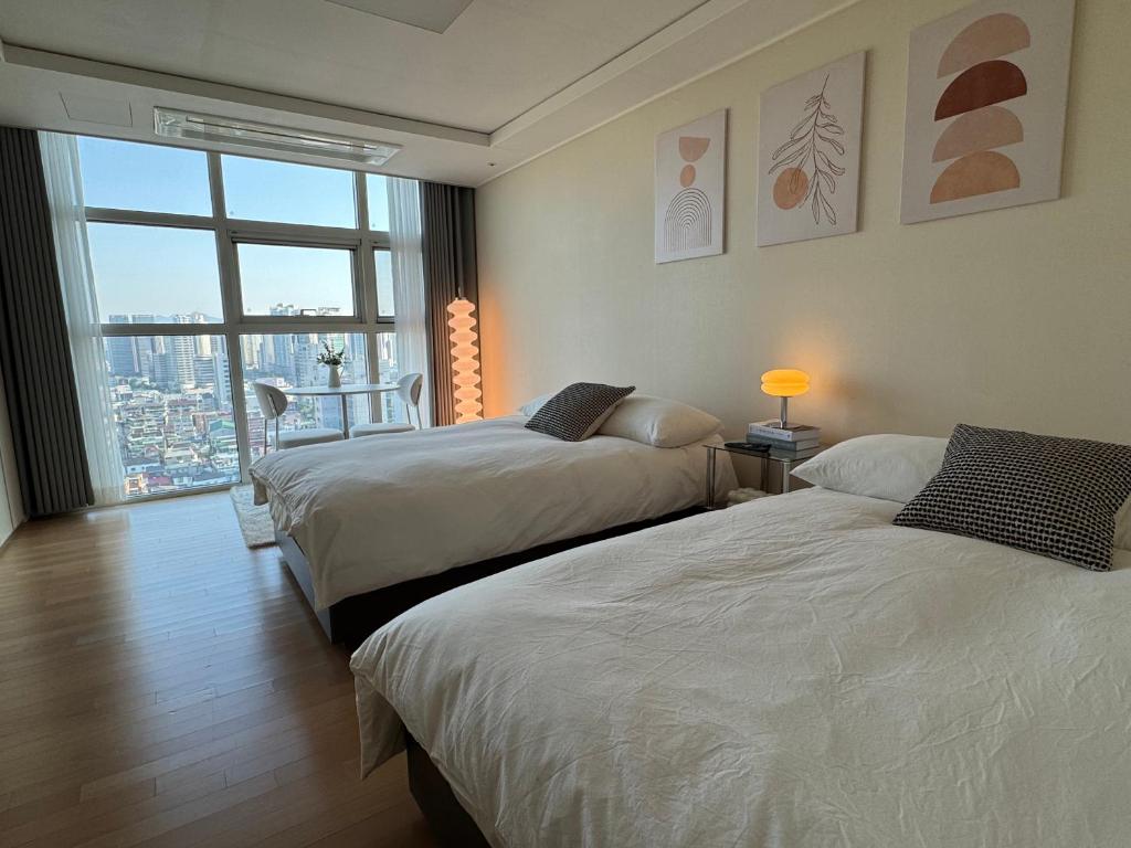 a hotel room with two beds and a window at Seoul Station Studio-City View in Seoul