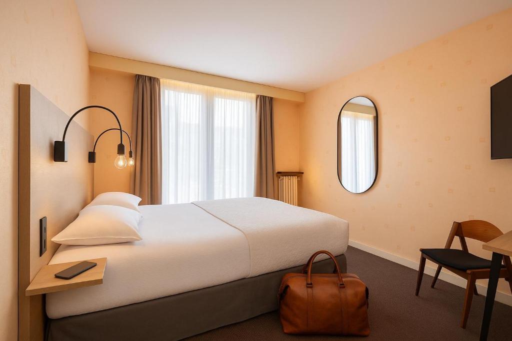 Postel nebo postele na pokoji v ubytování Cit'Hotel Logis De Brou, Bourg en Bresse